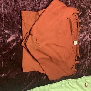 Burgundy colored cop top with slits in the top of the sleeves